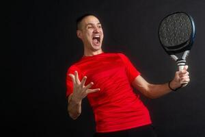 Man plays paddle tennis and poses in studio photos on white black background