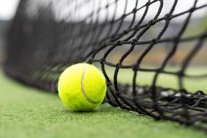 Tennis Ball on the Court against the Court Net photo