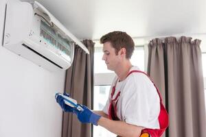 Professional technician maintaining modern air conditioner indoors. photo