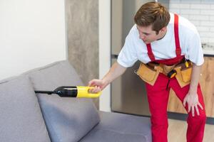 hombre seco limpiadores empleado mano en protector caucho guante limpieza sofá con profesionalmente extracción método. temprano primavera regular limpiar. comercial limpieza empresa concepto. foto