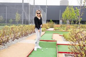 Playing Adventure Golf, downhill shot, ball, club and hole. photo