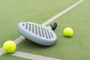 Paddle racket, next to the ball and on a carpet of the play area photo