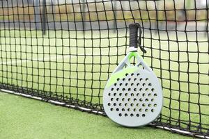 Paddle racket, next to the ball and on a carpet of the play area photo