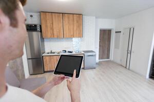 Worker with tablet computer checking alarm system indoors. photo