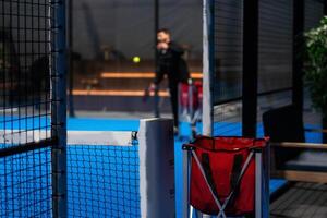 Twoo balls next to the net of a blue paddle tennis court. Sport healthy concept. photo