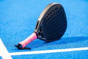 Paddle racket, next to the ball and on a carpet of the play area photo