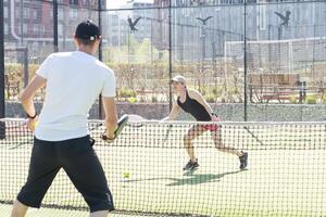 Portrait of two smiling sportsman's posing on padel court outdoor with rackets - Padel players photo