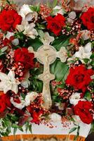 Cross surrounded by red and white flowers photo