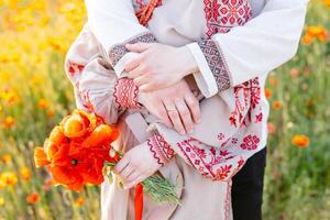 Man and woman holding each other in field of flowers photo