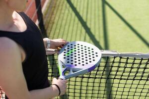 A girl with a paddle racket on an outdoor court. Concept of women playing paddle. Paddle sport. Ukraine Kyiv, April 02 2024 photo
