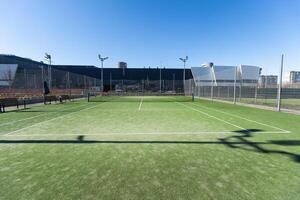 Landscaped areas of a residential development with a tennis court with high Plexiglas and metal fences photo