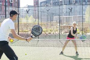 Ukraine Kyiv, April 02 2024. Padel training coach in a session, mentoring a female student, fostering skill development and a positive learning environment photo