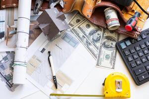 trabajando en construcción proyecto antecedentes. oficina mesa con dolares y bolígrafo foto