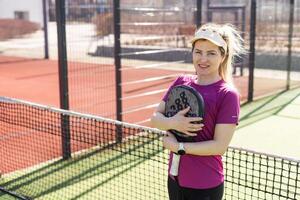 Ukraine Kyiv, March 31 2024. A girl in sportswear is training on a paddle tennis court. Concept of women playing paddle. photo
