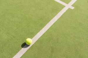 Tennis ball on a tennis court next to the side line photo