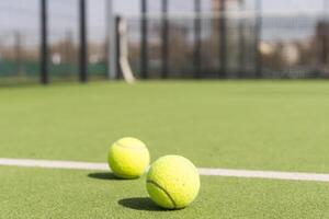 Bright greenish, yellow tennis ball on freshly painted court photo