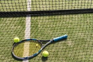 tennis racket with balls on green background. photo