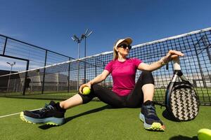 Happy female paddle tennis player during practice on outdoor court looking at camera. Copy space. photo