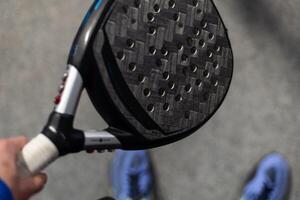 Paddle tennis. Paddel racket and ball in front of an outdoor court photo