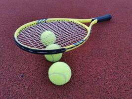 Tennis racket and ball on a hard tennis court photo