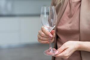 hand holding Empty wine glass isolated on white background photo