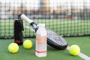 Paddle tennis racket, ball and net on the grass photo