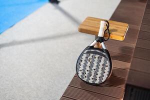 Paddle tennis. Paddel racket and ball in front of an outdoor court photo