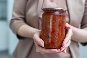 vegetable lecho in a glass jar on a white background photo