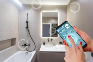 Female hands holding phone with app smart home screen in room house photo