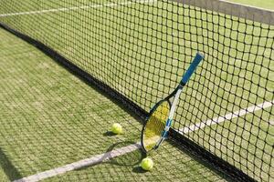 tennis racket with balls on green background. photo