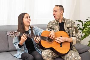 a veteran and his daughter play the guitar photo