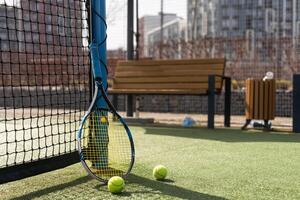 tennis racket with balls on green background. photo