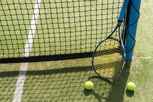 tennis racket with balls on green background. photo