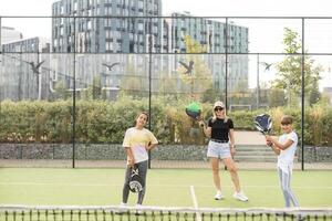 madre y hijas jugando padel al aire libre foto