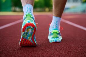 Runner athlete wearing running shoes at racing track photo
