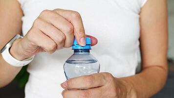 Flasche mit stationär Plastik Deckel im Frau Hand. das Neu Design meint das Deckel Überreste befestigt zu das Flasche nach Öffnung, Herstellung das ganz Paket Einfacher zu sammeln und recyceln. 4k Aufnahmen video