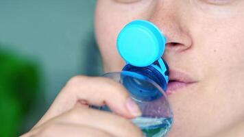 Young woman drinking from a bottle with stationary plastic cap. The new design means the cap remains attached to the bottle after opening, making the entire package easier to collect and recycle. video