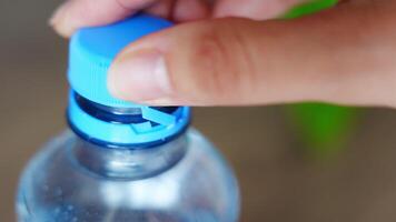 Stationary plastic cap on a PET bottle. The new design means the cap remains attached to the bottle after opening, making the entire package easier to collect and recycle. High quality 4k footage video