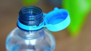 Stationary plastic cap on a PET bottle. The new design means the cap remains attached to the bottle after opening, making the entire package easier to collect and recycle. High quality 4k footage video