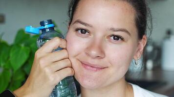 Jeune femme avec bouteille avec Stationnaire Plastique casquette. le Nouveau conception veux dire le casquette restes attaché à le bouteille après ouverture, fabrication le tout paquet Plus facile à collecte et recycler. video