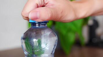 Stationary plastic cap on a PET bottle. The new design means the cap remains attached to the bottle after opening, making the entire package easier to collect and recycle. High quality 4k footage video