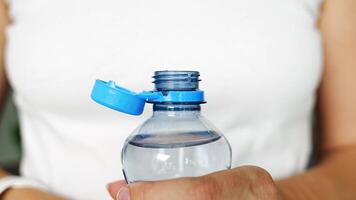 Flasche mit stationär Plastik Deckel im Frau Hand. das Neu Design meint das Deckel Überreste befestigt zu das Flasche nach Öffnung, Herstellung das ganz Paket Einfacher zu sammeln und recyceln. 4k Aufnahmen video