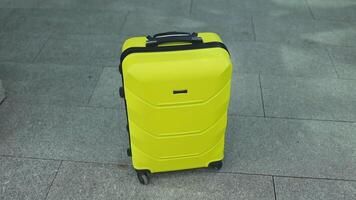 Stylish Plastic luggage suitcase standing at airport, Yellow travel bags waiting in terminal. Transportation and travelling video