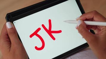 Person writing on tablet with marker JKO video
