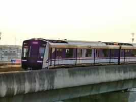 nonthaburi-tailandia abril dieciséis, 2024 el eléctrico cielo tren mrt púrpura línea pasa mediante central puerta oeste Departamento Tienda el más grande compras plaza en el noche a explosión sí, nonhaburi tailandia foto