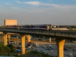 nonthaburi-tailandia abril dieciséis, 2024 el eléctrico cielo tren mrt púrpura línea pasa mediante central puerta oeste Departamento Tienda el más grande compras plaza en el noche a explosión sí, nonhaburi tailandia foto