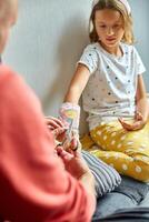 Father removing a plaster cast teen girl with a broken arm photo