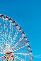 View of the Ferris wheel attraction against a background of blue sky. Ferris wheel in the Georgian city of Batumi. photo