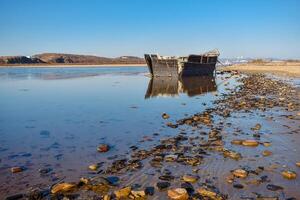 un abandonado coreano pescar barco lavado en tierra durante un tormenta. un antiguo pescar goleta lavado arriba en superficial agua durante un tormenta. foto