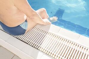 An elderly man and an outdoor pool on a sunny day on vacation. photo